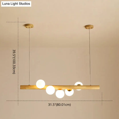 Modern minimalist linear island pendant with natural wood bar and five frosted glass globe bulbs for kitchen lighting