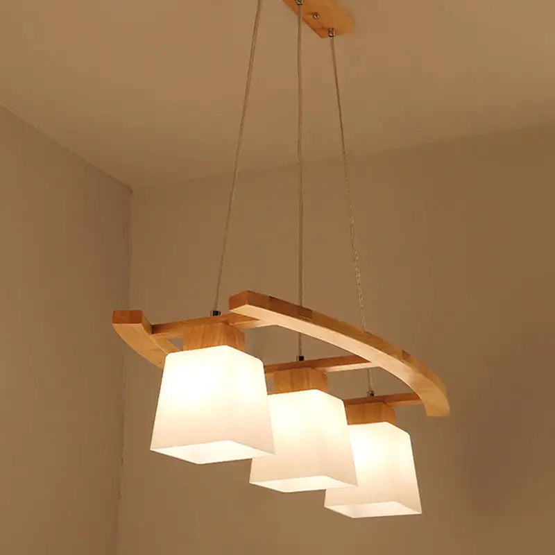 DecorBites™ ivory glass trapezoid island pendant light with three frosted shades and curved wood frame for dining room
