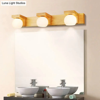 Light wood finished three-light vanity fixture with frosted white glass globe bulbs compatible with led incandescent fluorescent 220v-240v