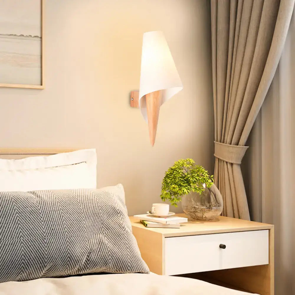 Modern minimalist wall-mounted light fixture with white fabric shade and light wood base for bedroom use