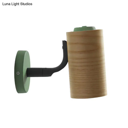 Minimalist wall light fixture with light wood cylindrical shade and green metal base for bathroom use