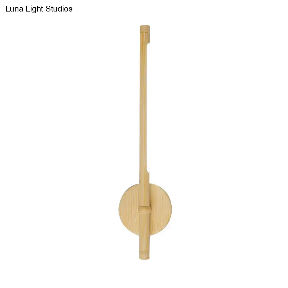 Minimalist yellow bamboo wall mounted sconce with slender stem and circular base emitting warm white natural light