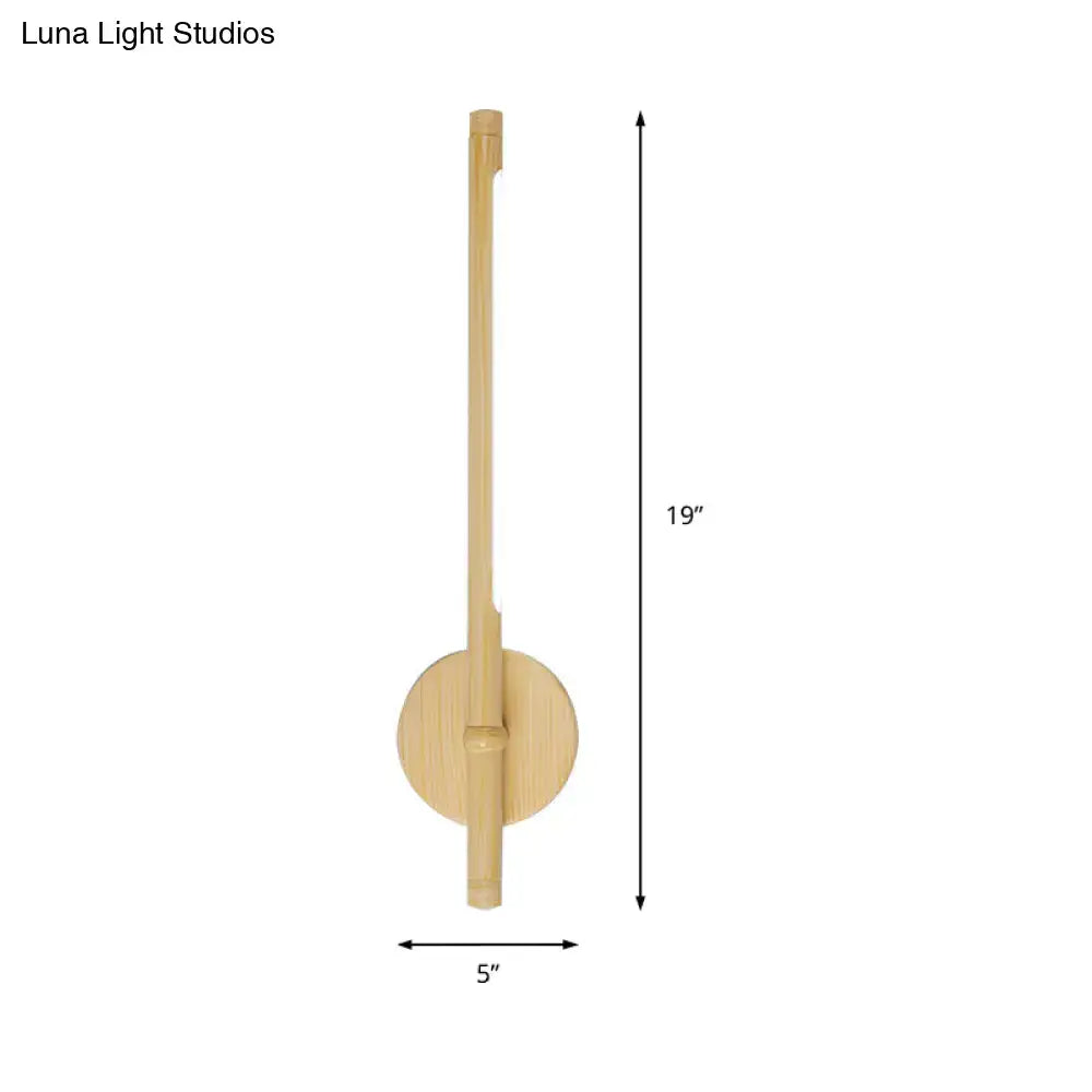 Minimalist yellow bamboo wall mounted sconce with warm white natural light, slender vertical stem, and circular base