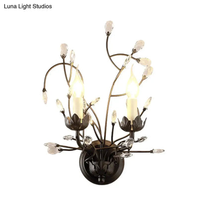 Antique bronze wall light sconce lamp with two candle-style lights and black crystal blossom accents for dining room