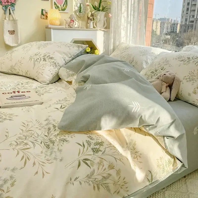 Soft sage green duvet cover with delicate leaf pattern and matching pillowcases in a floral print cotton bedding set