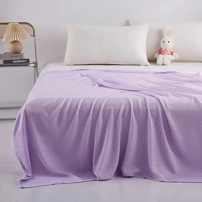A soft lavender knit throw blanket with waffle texture complements the mint green decorbites bamboo fiber cooling summer blanket