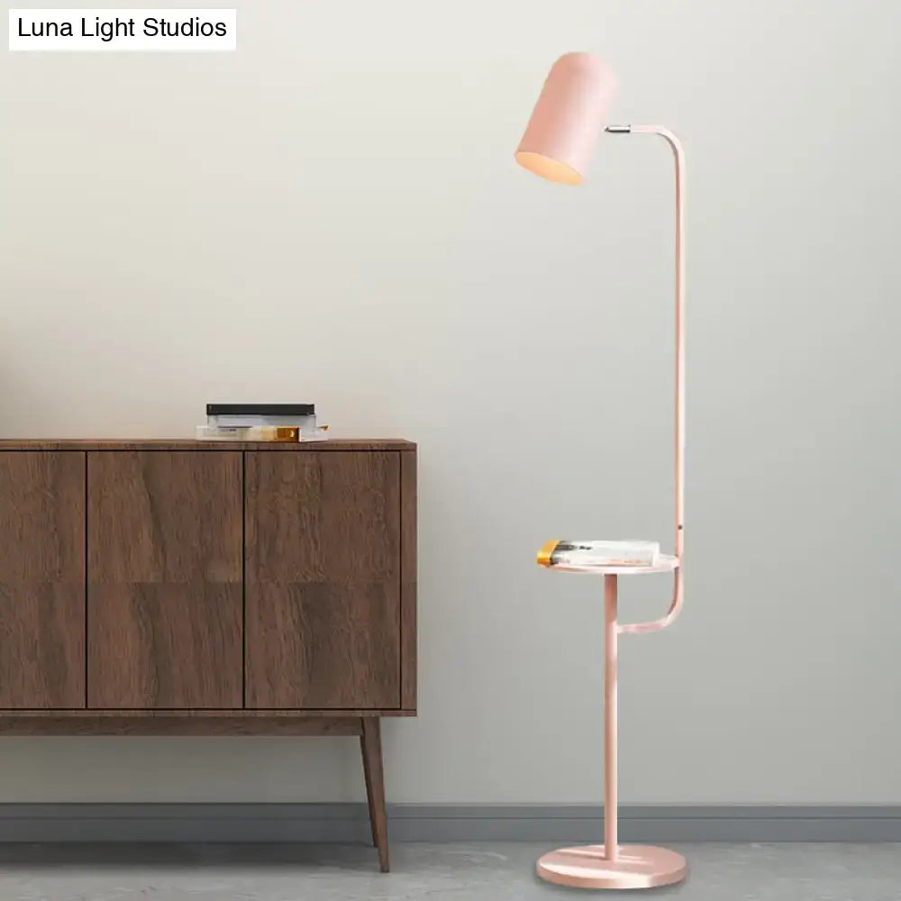 A sleek rose gold metal floor light with curved neck and adjustable shade featuring pink yellow green bulbs for reading