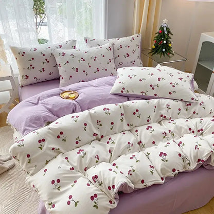 White quilted duvet cover with red cherry cartoon heart plant prints paired with matching pillowcases on lavender bedspread