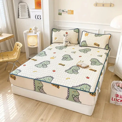 Cute mint green dinosaur summer quilt with cream base and teal trim paired with a latex fitted sheet set