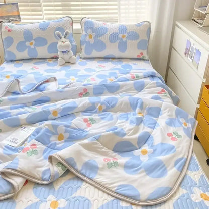 Blue and white floral patterned quilt set with embroidered details paired with a mint green latex fitted sheet set