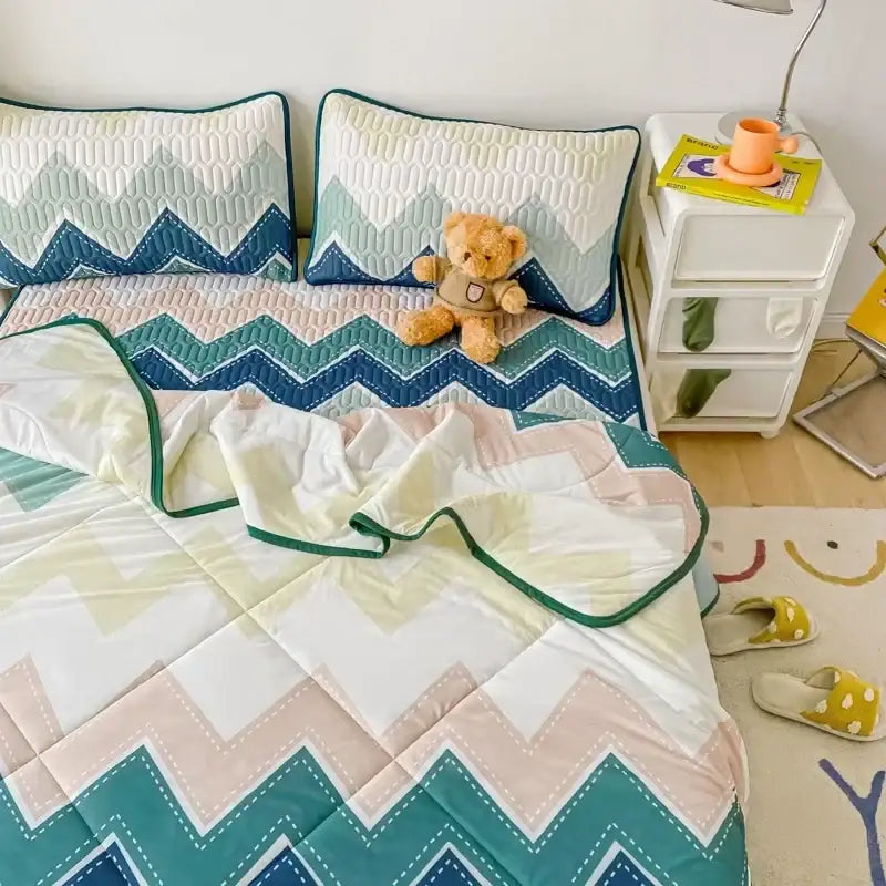 Cozy mint green dinosaur summer quilt with teal cream and pink zigzag pattern paired with latex fitted sheet set