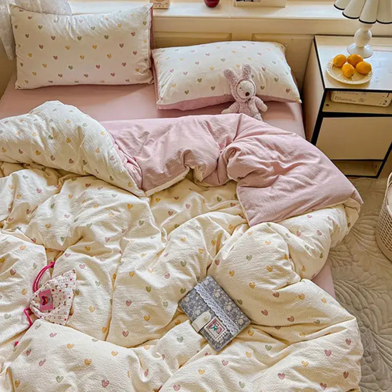 Cozy cream-colored quilt duvet cover set with soft pink lining and pastel heart patterns for bedroom use