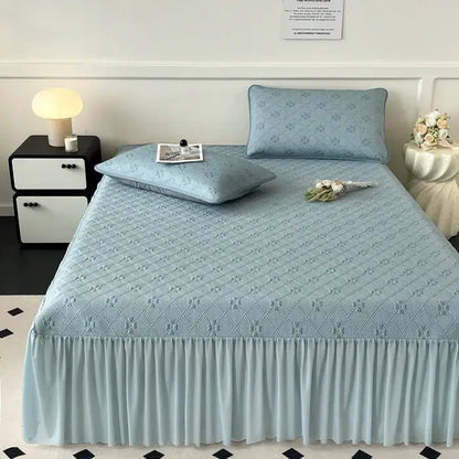 Light blue quilted bed skirt set with subtle floral pattern and ruffled hem for bedroom mattress mat use