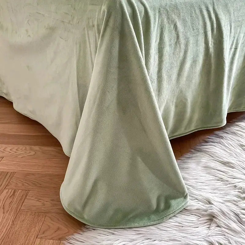 A mint green fluffy faux fur bedding set with a soft textured blanket draped over a bed edge for cozy decorbites decor