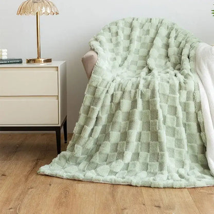 A soft mint green plush geometric jacquard flannel sofa cover draped over an armchair for living room decor