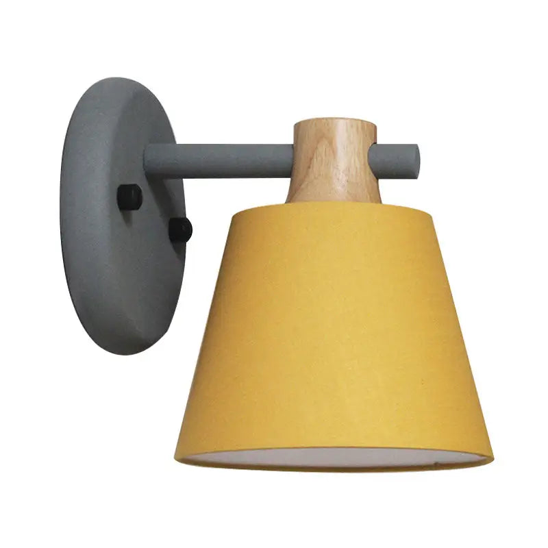 Mint green nordic bucket wall lamp with yellow conical lampshade and wood accent mounted on gray metal arm