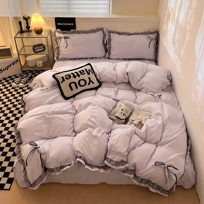 Mint green ruffled cotton embroidery bedding set featuring a soft lavender quilt with decorative black bows and layered design