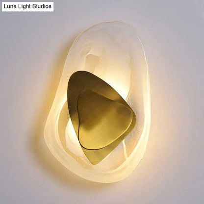 Modern abstract clear glass rock wall sconce with frosted glass and layered brass plates in black and gold direct wired electric design