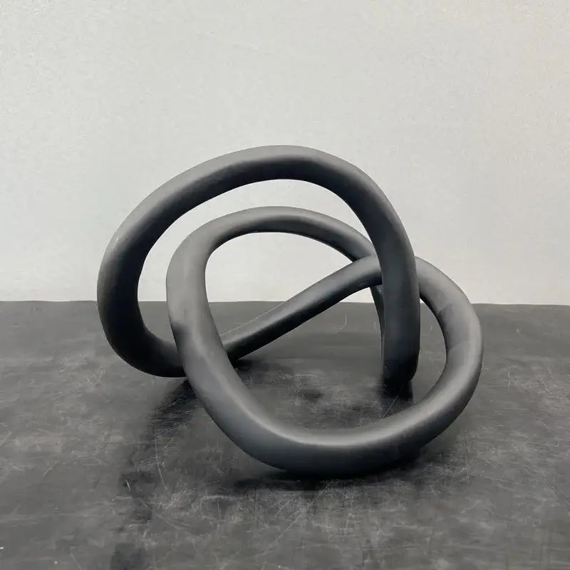 Black ceramic modern abstract sculpture with interlocking gold ring knot for living room art decor