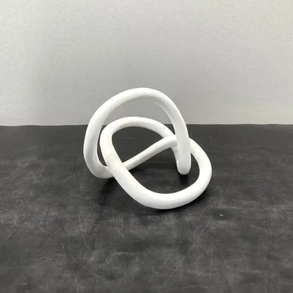 White ceramic minimalist gold ring knot sculpture with smooth rounded loops for modern living room art decor