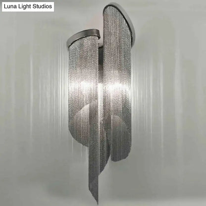 Silver chain-link wall light with modern flowing design and tassel aluminum shade for living room decor