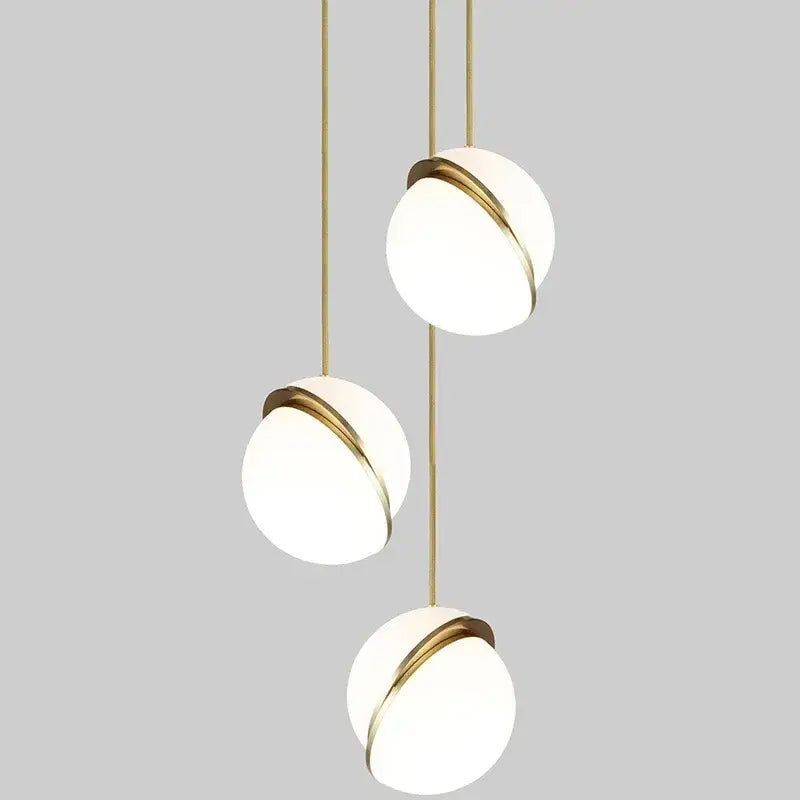 Modern acrylic ball pendant lamp featuring three white glass shades with gold metal rings for living room lighting