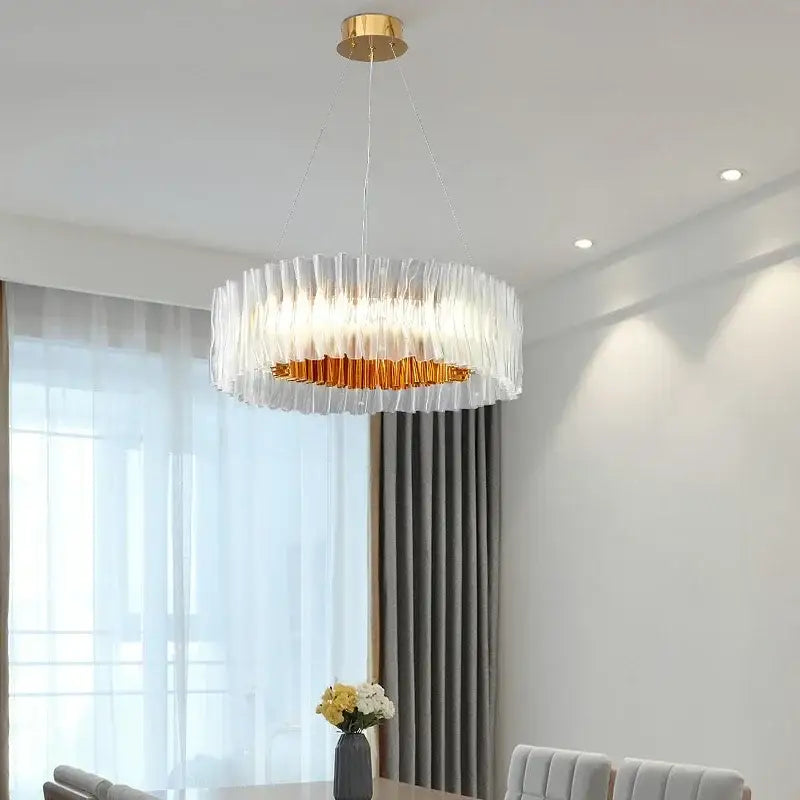 A modern acrylic ceiling chandelier with translucent ribbed glass panels and a gold ring for dining room lighting