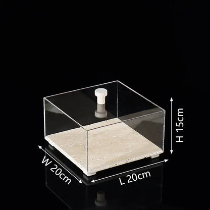 Modern acrylic display case with clear square design, white knob, and textured beige travertine base for dining room