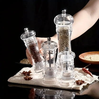 Modern acrylic manual pepper grinder set with clear glass bodies metallic tops filled with peppercorns and coarse salt