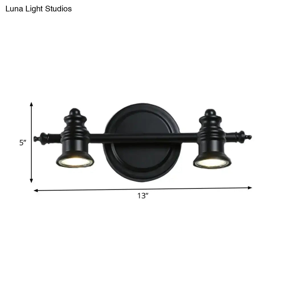 Black matte wall light fixture with two adjustable spotlights and circular mounting plate for bathroom vanity use