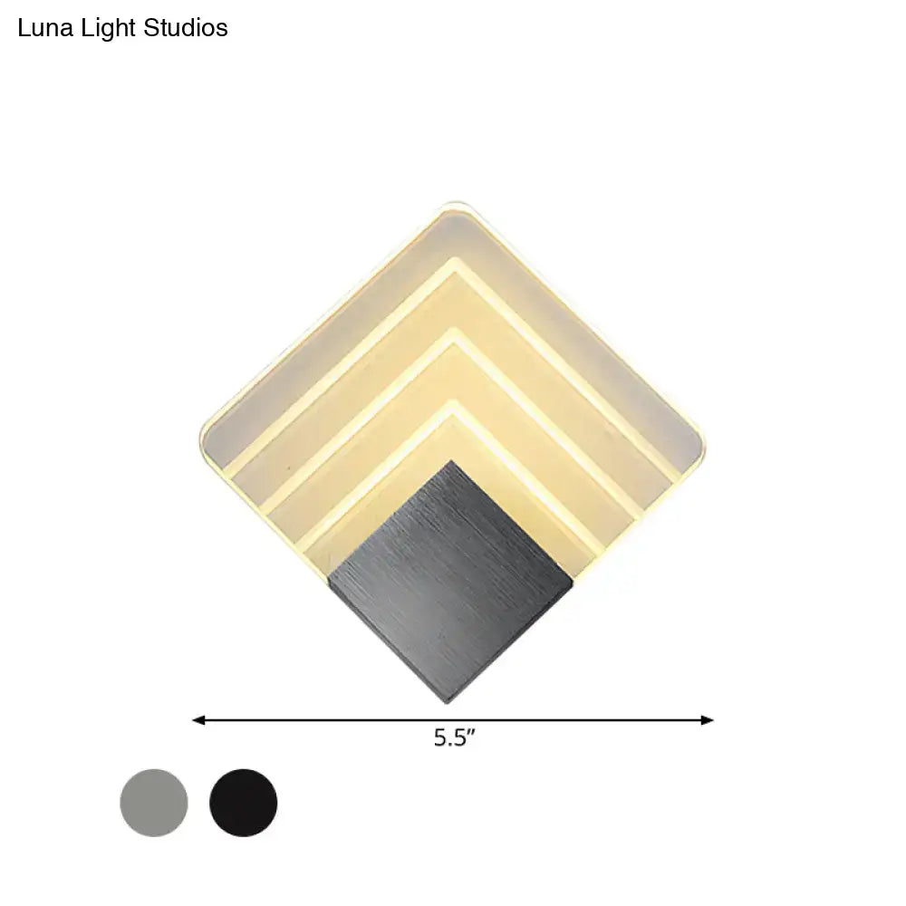 Modern aged silver and black square led wall sconce with diamond-shaped layered illuminated panels in warm beige