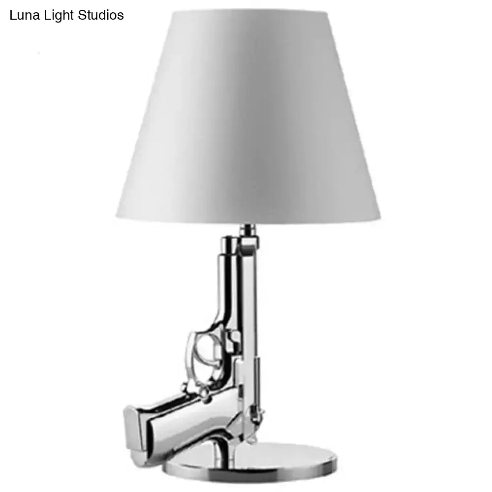 Modern ak47 gun lounge floor lamp with chrome finish pistol base and white conical shade in silvery gold lustre