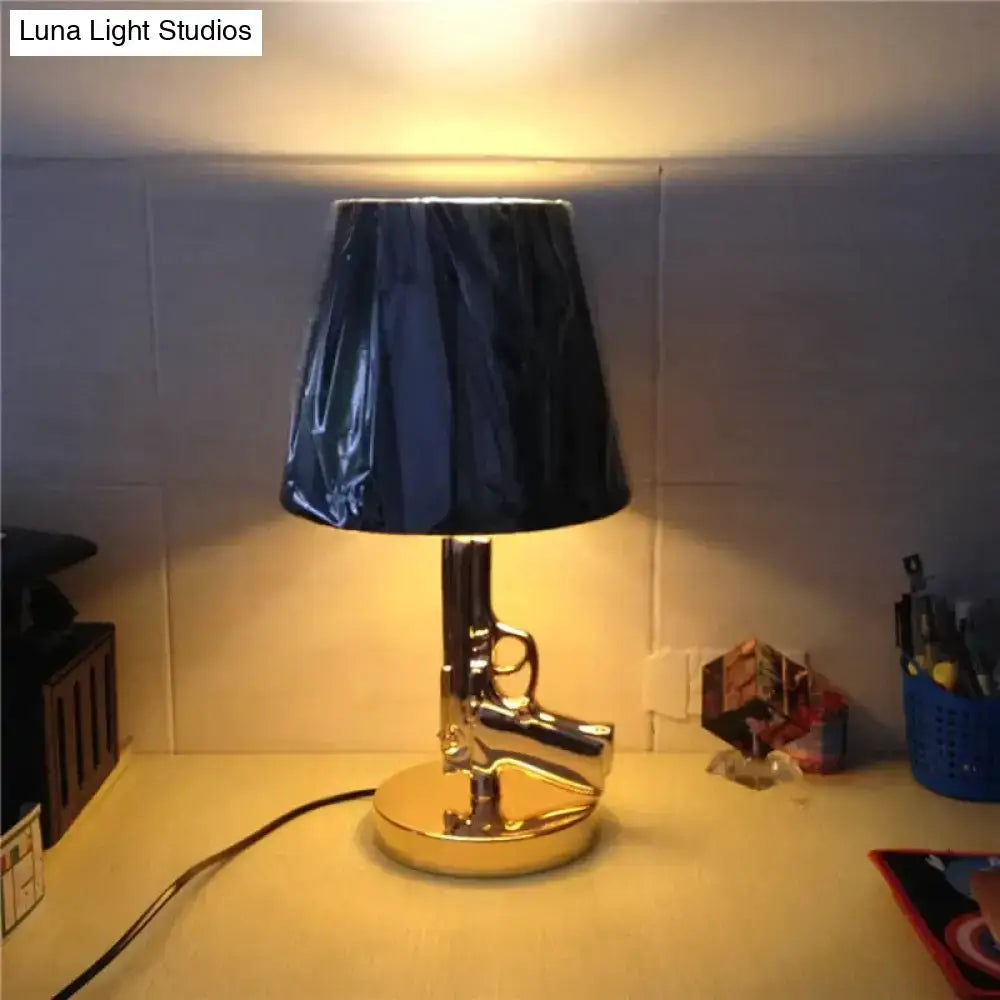 Modern ak47 gun lounge floor lamp with shiny chrome handgun base, silvery gold lustre, and black drum shade for bedrooms