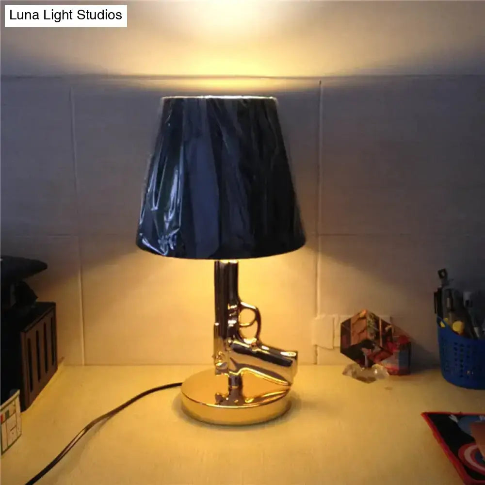 Modern ak47 gun lounge floor lamp with shiny chrome handgun shape dark blue fabric shade and silvery gold lustre base