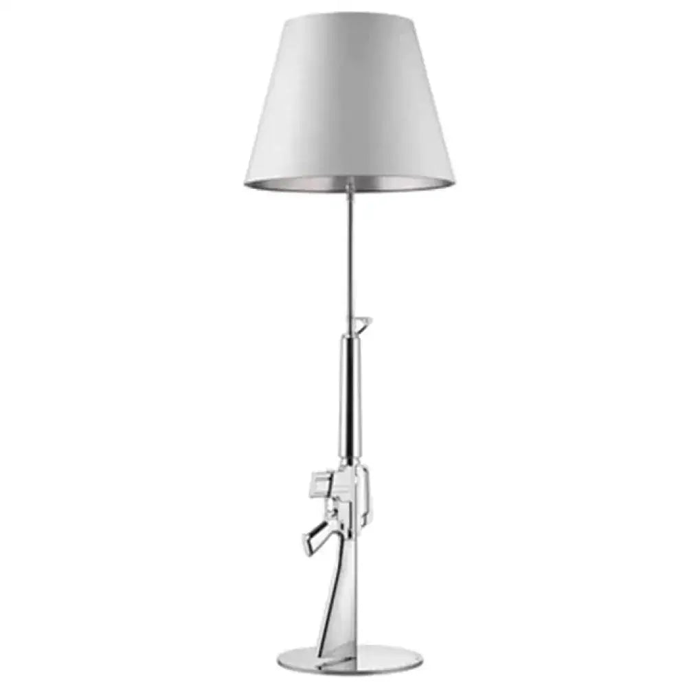A modern ak47 gun lounge floor lamp with silvery gold lustre, chrome finish, adjustable height, and white conical shade
