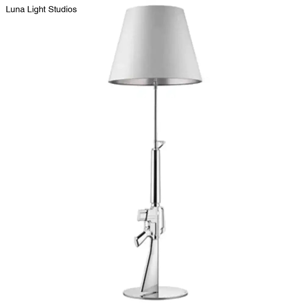 A modern ak47 gun lounge floor lamp with silvery gold lustre chrome finish and white conical shade, adjustable height