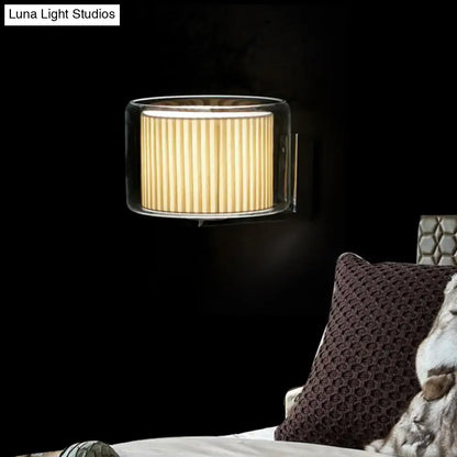 Modern amber and black wall lamp with a clear glass frame and warm pleated fabric shade for bedroom lighting