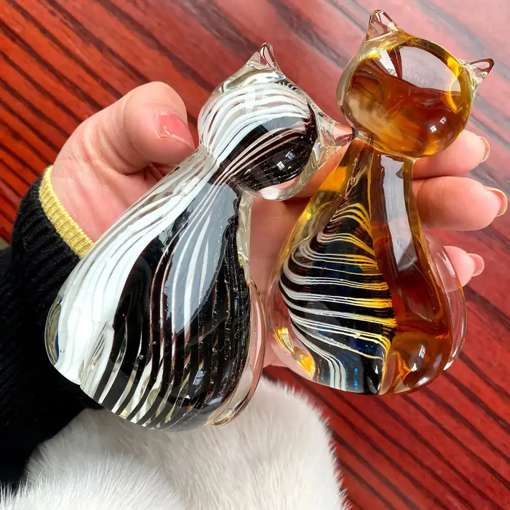 Two hand-blown glass cat figurines with black white and amber gold swirls for modern living room decor