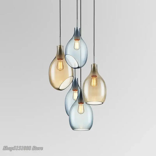 Modern amber and blue glass pendant lights with warm bulbs designed as kitchen pendant lights