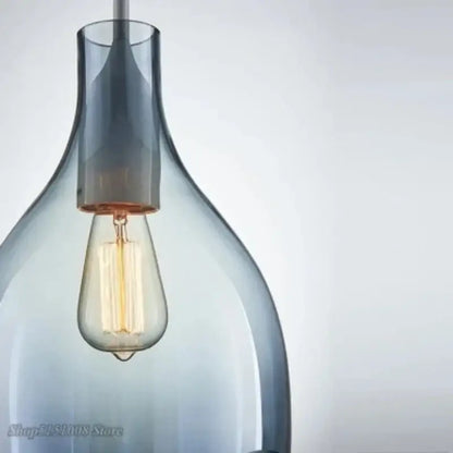 A sleek translucent gray glass pendant light with warm-toned filament bulb for modern kitchen pendant lights