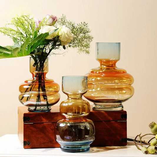 Three amber and blue decorbites gradient glass vases with layered bulbous design on wooden box for living room decor
