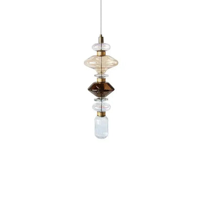 A modern amber and brown glass ballet pendant lamp with stacked orbs and brass accents for dining room use
