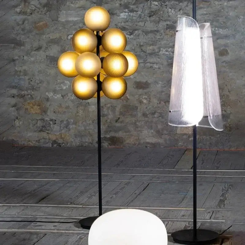 Modern amber bubble glass lamp set featuring a golden spherical globe floor lamp with black metal stand for living room