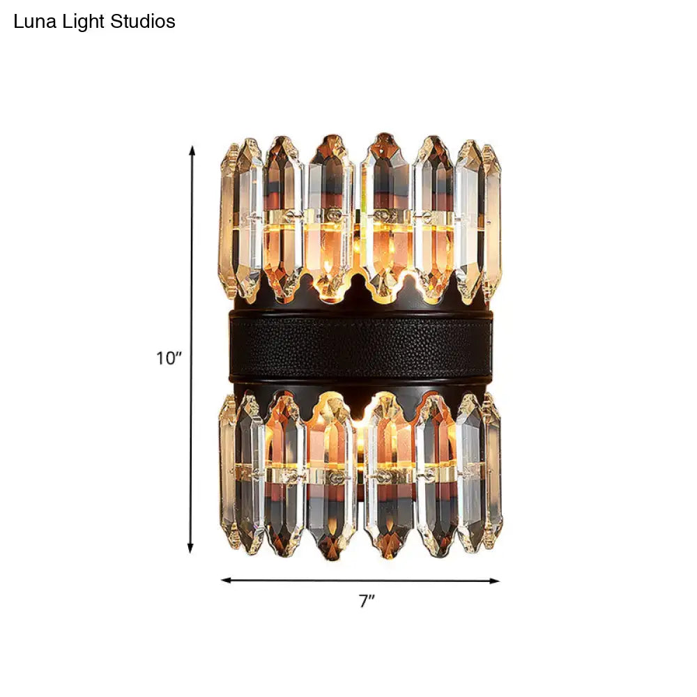 A modern amber and clear crystal wall sconce with a black textured band featuring direct wired power source