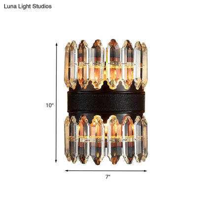 A modern amber and clear crystal wall sconce with a black textured band featuring direct wired power source
