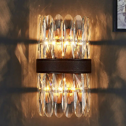 Modern amber and clear crystal wall sconce with faceted glass and dark brown leather strap direct wired electric light