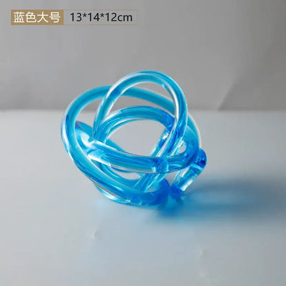 Modern amber and clear glass knot twist sculpture featuring a translucent blue coiled decorbites glass knot design