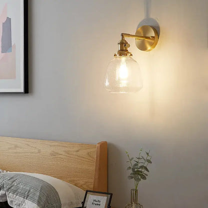 Modern amber clear glass wall sconce with gold-toned brass finish and textured clear glass by decorbites clear glass