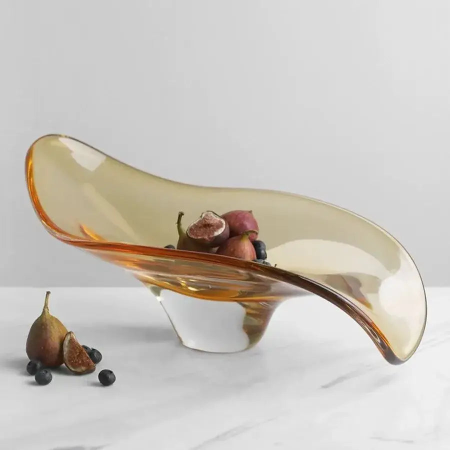 A sleek amber geometric glass bowl tray with modern flowing design and white base for dining room decorbites decor