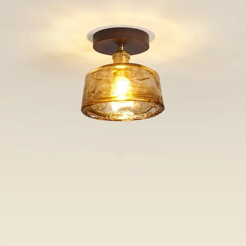 Modern amber glass and brass led ceiling lamp with warm tones and dark wood mount for dining room lighting